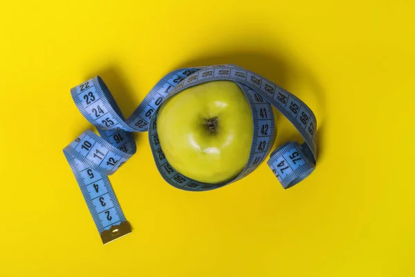 Amarelo Apple Com Fita Métrica Azul Uma Dieta Fundo Amarelo — Fotografia de Stock