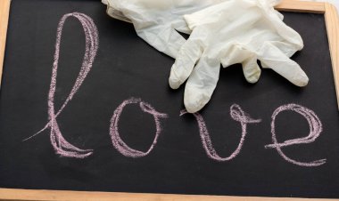 Tahta ve beyaz lateks eldivenler. Tebeşirle yazılmış aşk sözcüğü..