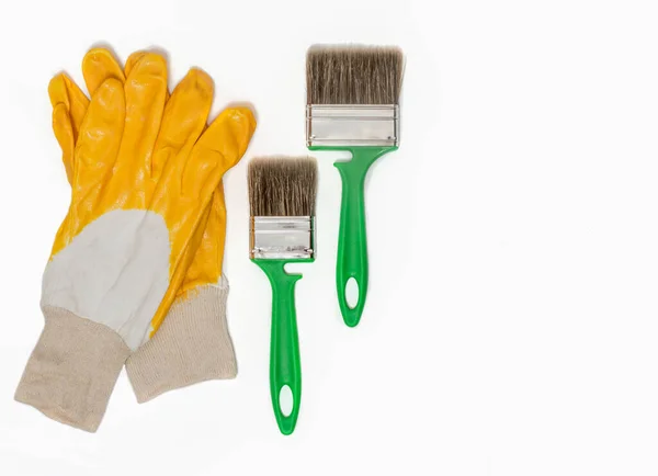 Κατασκευή Προστατευτικά Γάντια Κίτρινο Χρώμα Ένα Πράσινο Πινέλο Λευκό Φόντο — Φωτογραφία Αρχείου