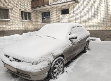 Girişteki araba karla, karla kaplanmış..