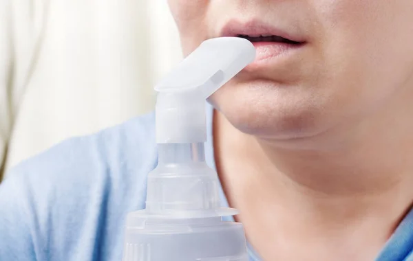 modern medicine, woman doing inhalation for cough and sore throat close-up.