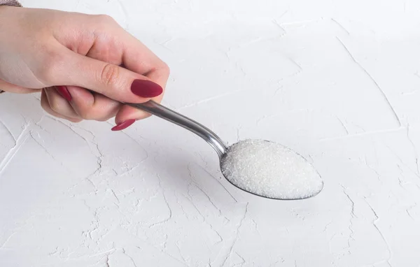 Cucchiaio Zucchero Semolato Nelle Mani Una Donna Uno Sfondo Bianco — Foto Stock