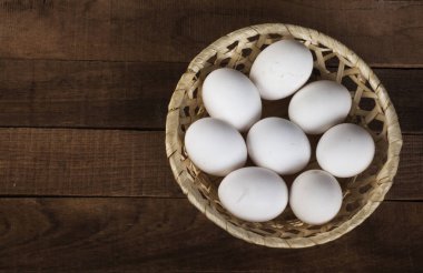 Hasır plakalı, beyaz yumurtalı, kahverengi arka planda, üst manzaralı, boşluğun bir kopyası var..