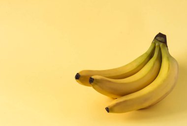 Sarı arka planda bir grup sarı muz ve boşluğun bir kopyası..