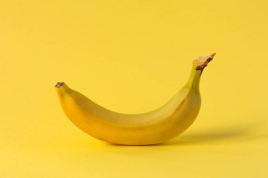 Sarı arka planda bir sarı muz duruyor..
