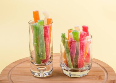 Doğulu şekerlemeler, sarı arka planda iki bardak içinde ananas şekerlemeleri..