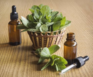 Sepette nane şekeri ve ahşap arka planda cam kavanozlarda naneli kozmetik yağlar..