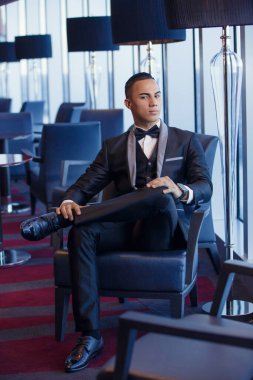 Resmi giyinmiş zarif, genç, moda Latin bir adamın portresi.