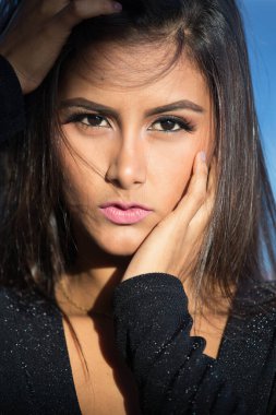 Muhteşem siyah gece elbisesi içinde zarif genç bir kadının portresi.