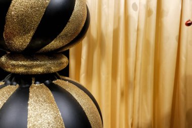 Noel ve Yeni Yıl şenlikli altın top dekorasyonu siyah bokeh arka planına karşı. Kış tatili kavramı