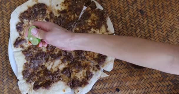 Gros plan d'une main serrant du citron vert et mettant des épices sur Manakish Lahm Bi Ajeen - Pains plats à l'agneau haché ou au bœuf et tarte farcie Fatayer aux épinards. Nourriture arabe traditionnelle — Video