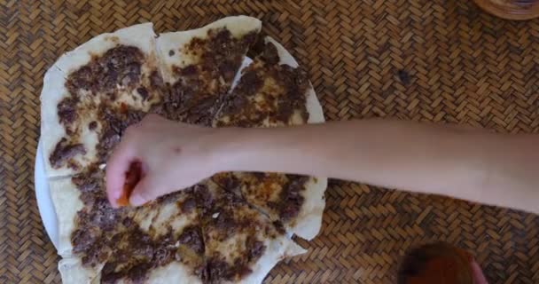 Gros plan d'une main mettant des épices sur Manakish Lahm Bi Ajeen - pains plats à l'agneau haché ou boeuf et tarte farcie Fatayer aux épinards. Nourriture arabe traditionnelle — Video