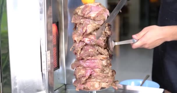 Close up de homens mão cortando carne espetada tradicional shawarma ou kebab na grelha. Lanche árabe Levantine popular — Vídeo de Stock