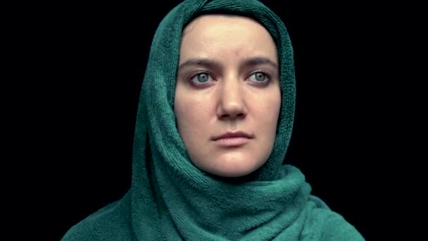 Portrait of womans head wrapped with green towel over black background — Stock Video