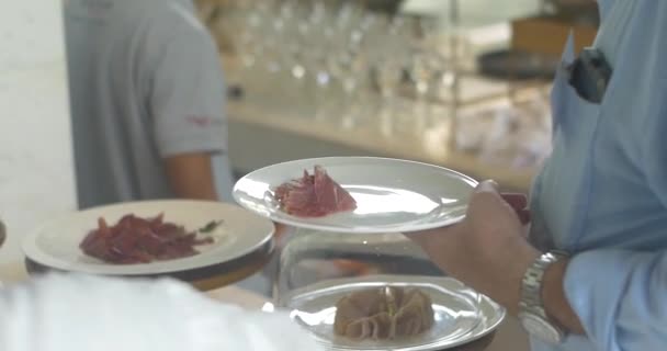 Primo piano di cameriere con guanti e maschera di protezione che mette salumi in un piatto di ospite. Servizio catering durante la pandemia. Nuovo concetto normale — Video Stock