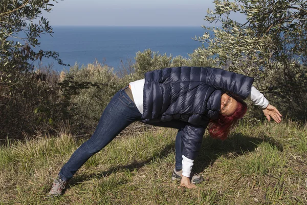 Woman relaxing, performing joga on sea coast — Stock Photo, Image