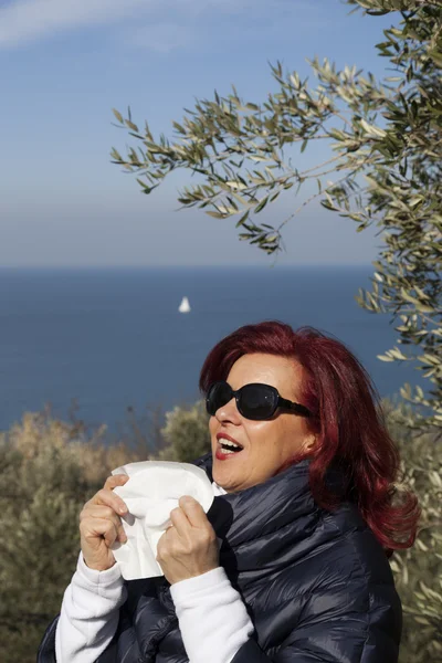 Donna starnutisce, soffia naso nel tessuto sopra la costa del mare — Foto Stock