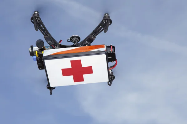 Quadrokopter-Drohne transportiert Koffer mit medizinischem Material Stockbild