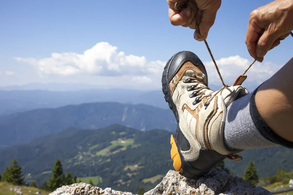 Caminante atando cordones de bota, alto en las montañas —  Fotos de Stock