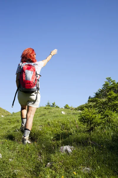 Mulher caminhante a caminho do pico da montanha — Fotografia de Stock