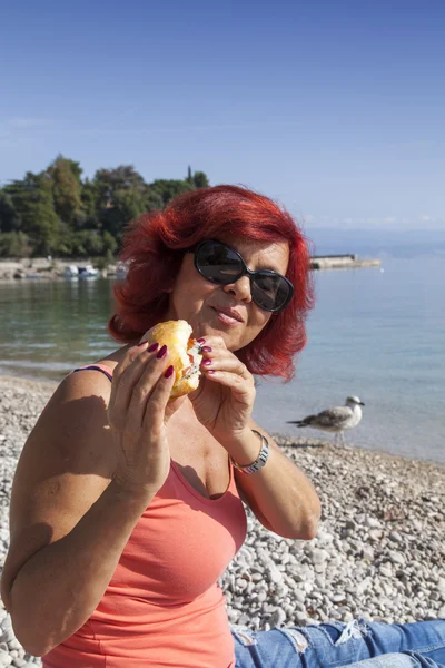 Pretty woman enjoying fresh sea food sandwich — Stock Photo, Image