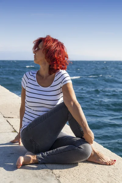 Женщина, исполняющая джогу на морском побережье, в ветреный солнечный день — стоковое фото