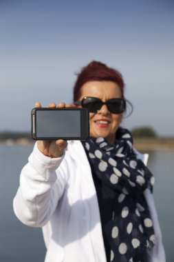 Güzel bir kadın telefon boş ekran gösterir