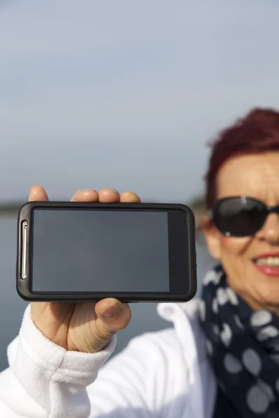 Jolie femme montre téléphone écran vierge — Photo