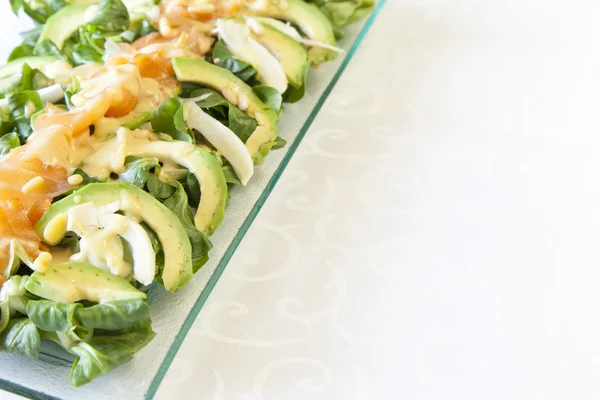 Closeup of healthy salmon salad with avocado and organic vegetables