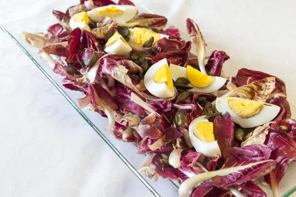 Hard-boiled eggs with organic red chicory — Stock Photo, Image