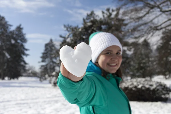Adorável jovem mulher mostrando coração de neve — Fotografia de Stock