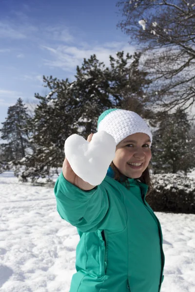 Bella giovane donna mostrando cuore di neve — Foto Stock