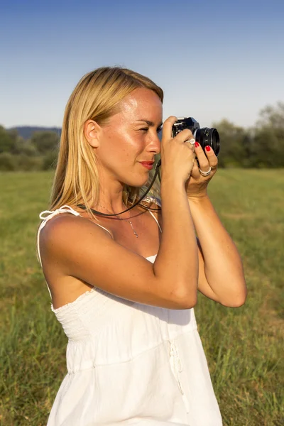 Hezká blondýnka žena s vinobraní fotoaparát — Stock fotografie