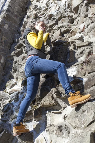 Niña escalador usando el teléfono celular durante la escalada — Foto de Stock