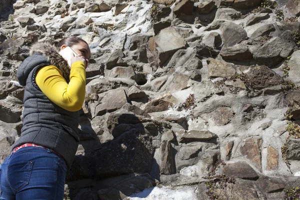 Niña escalador usando el teléfono celular durante la escalada — Foto de Stock