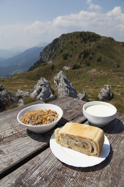 Delicius mat på ett träbord som hög i bergen — Stockfoto