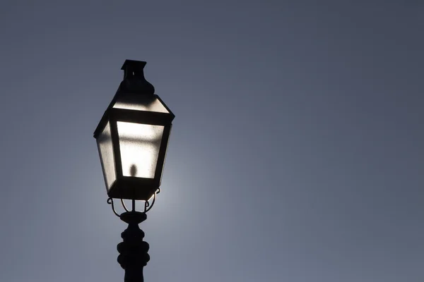 Gamla gatan lampa mot dramatiska blå himmel — Stockfoto