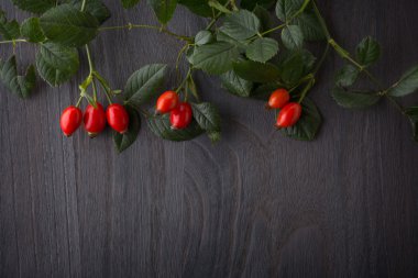 hips berries on rustic  wood  background clipart