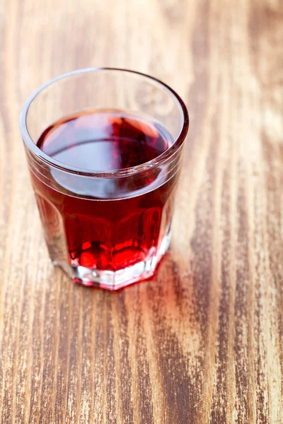 Einzelnes Glas mit rotem Getränk Stockbild