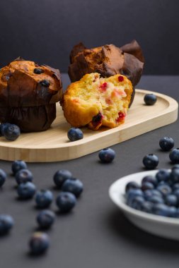 Taze pişmiş kekler ahşap bir tepside düzenlenir. Bazı çörekler bir bütün iken, bir tanesi içini göstererek ikiye bölünmüş. Yabanmersini her yere konur..