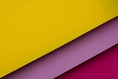 Sarı, pembe ve mor üç sayfa kağıt katmanlar halinde serilmiştir. Düzenleme renklerin net görünmesini ve pürüzsüz yüzeylerinin görünmesini sağlıyor. Sahne parlak ve basit..