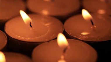 Dönen standın üzerinde yanan kırmızı mumların sığ alan derinliği