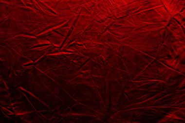 Kırmızı bir kumaş parçası görünür kırışıklıklar ve kıvrımlarla gösterilir. Çeşitli ortamlarda olaylar, gösterimler veya sanatsal projeler için zemin olarak kullanılabilir.