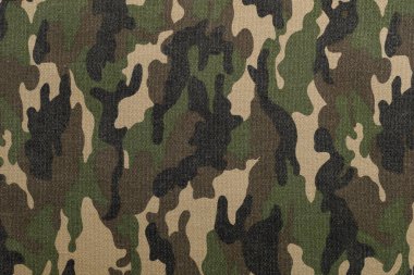 Kumaş, yeşil, kahverengi ve bronzlaşmış çeşitli tonlarda bir kamuflaj deseni gösteriyor. Bu tarz genellikle askeri kıyafetler ve açık hava giysilerinde uyum sağlamak için kullanılır..