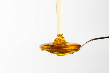 Basit ve temiz bir ortamda bal damlaları sunumlar, pazarlama ve tasarım gibi çok yönlü kullanımlar için bir odak noktası oluşturur. Sahne pürüzsüz bir doku sergiliyor..