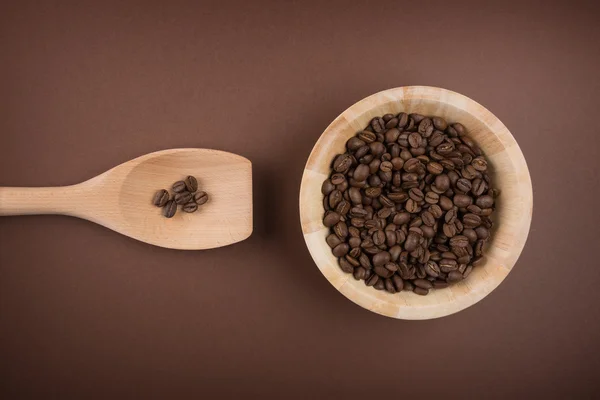 Granos de café en tazón sobre fondo marrón —  Fotos de Stock