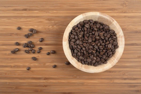 Granos de café en tazón sobre fondo de madera — Foto de Stock