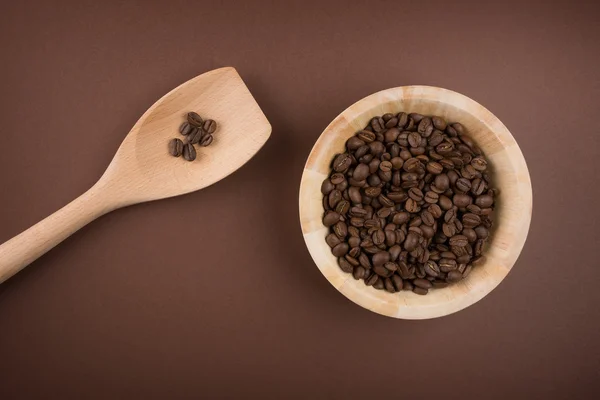 Kaffebönor i skål på brun bakgrund — Stockfoto