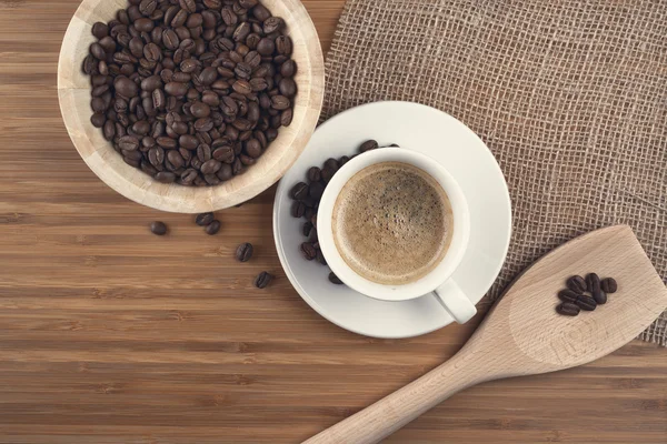 Kaffebönor i skål på trä bakgrund — Stockfoto