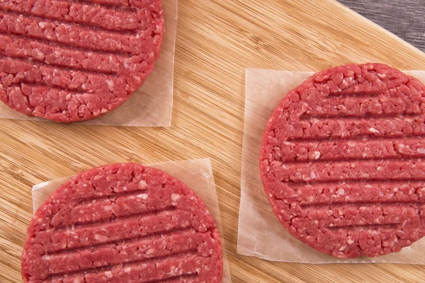 Burger patties pe scândură de lemn — Fotografie, imagine de stoc